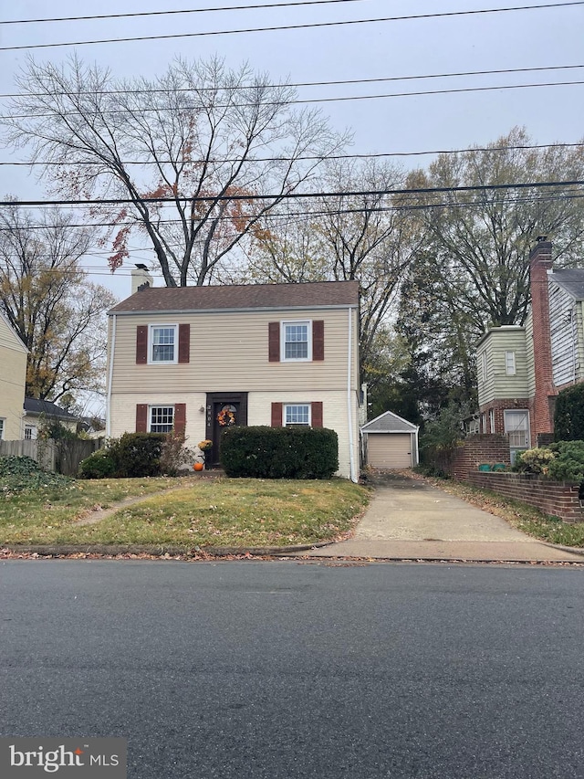 bi-level home featuring a garage, an outbuilding, and a front lawn