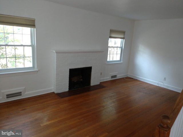 unfurnished living room with a fireplace and dark hardwood / wood-style flooring