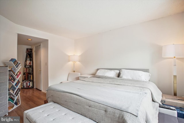 bedroom with dark hardwood / wood-style floors