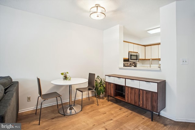 dining area featuring light hardwood / wood-style floors and sink