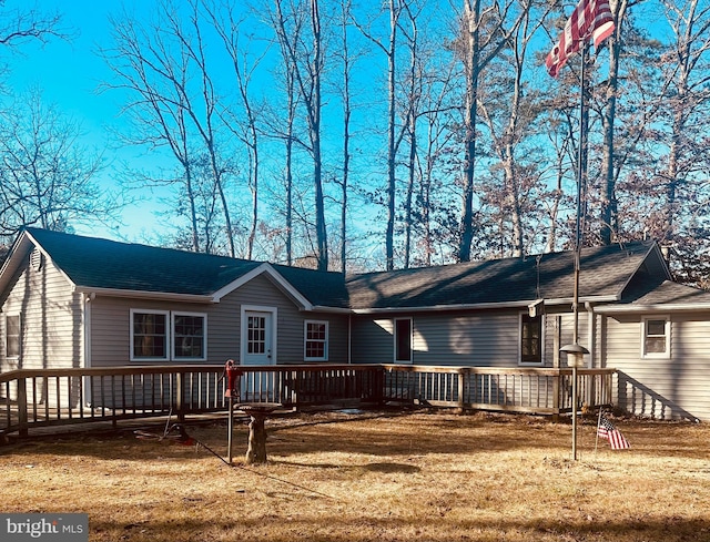 rear view of house with a deck and a yard