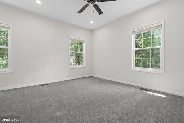 carpeted empty room featuring plenty of natural light and ceiling fan