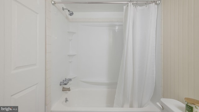 bathroom with shower / bath combination with curtain and toilet