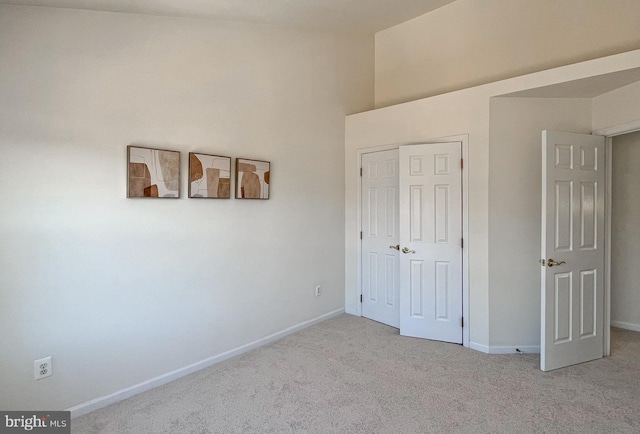 unfurnished bedroom featuring light carpet and a closet