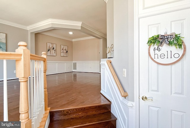 stairway with hardwood / wood-style flooring and crown molding