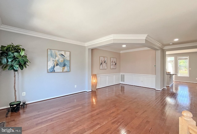 unfurnished living room with wood-type flooring and ornamental molding