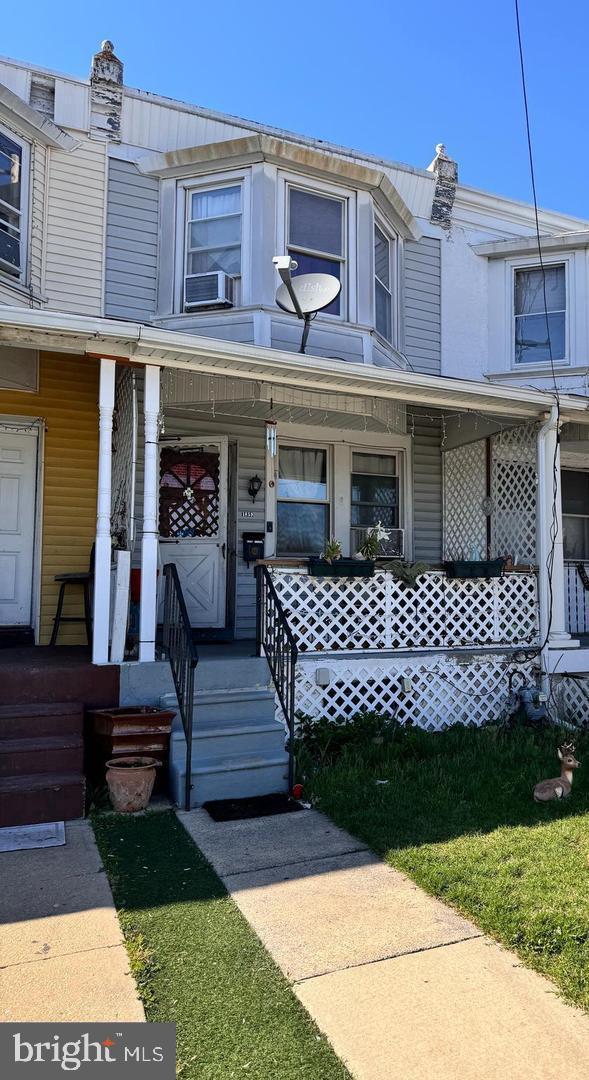 townhome / multi-family property with cooling unit and covered porch