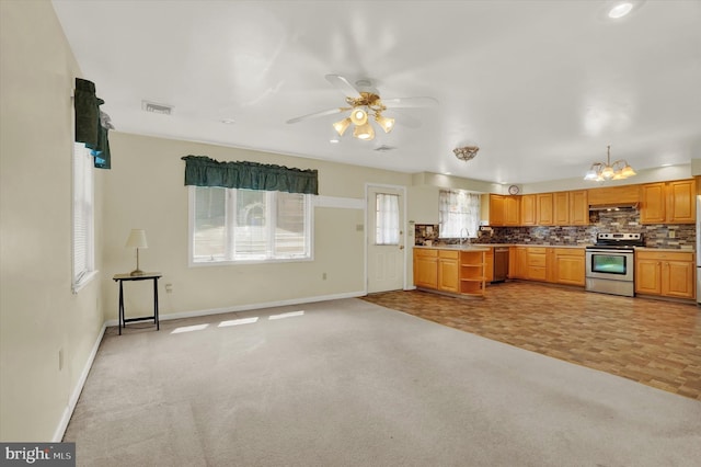 kitchen featuring decorative backsplash, appliances with stainless steel finishes, ceiling fan with notable chandelier, exhaust hood, and light parquet flooring