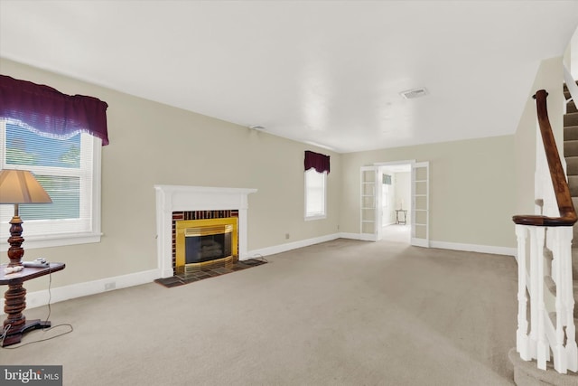 unfurnished living room featuring carpet and a brick fireplace