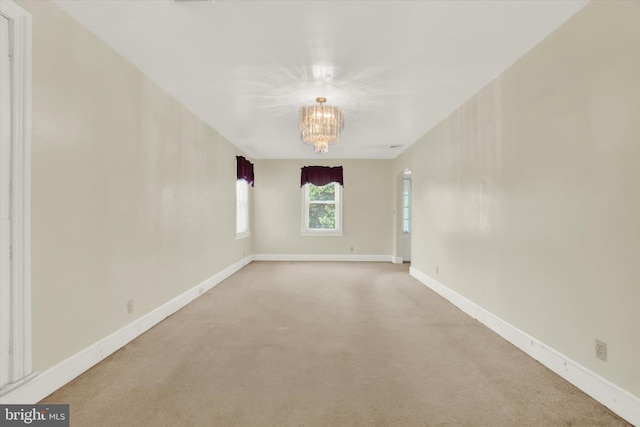 unfurnished room featuring carpet and a notable chandelier