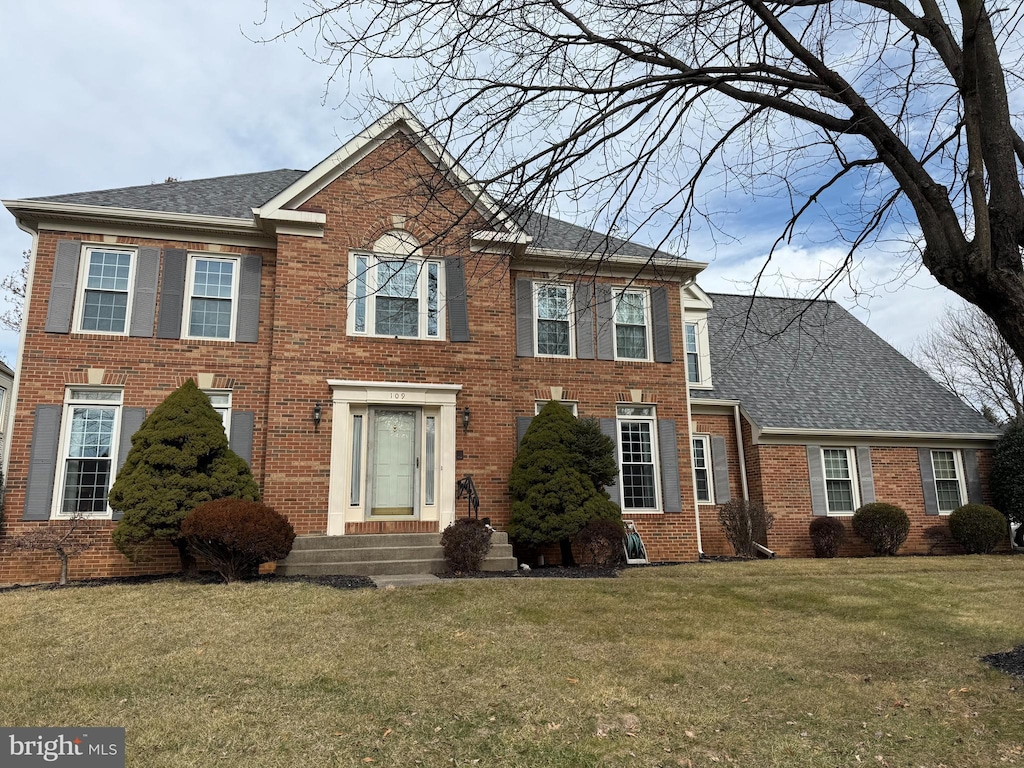 colonial inspired home with a front lawn