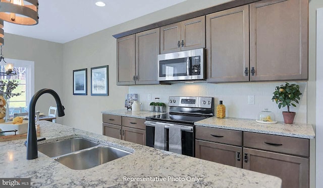 120 Forge Dr, Lebanon, PA 17042 - kitchen featuring sink, tasteful backsplash, decorative light fixtures, light stone counters, and stainless steel appliances