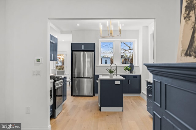 kitchen with a center island, hanging light fixtures, a chandelier, light hardwood / wood-style floors, and appliances with stainless steel finishes