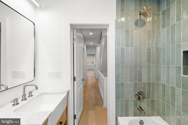 bathroom with vanity, tiled shower / bath combo, and hardwood / wood-style flooring