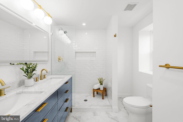 bathroom with tiled shower, vanity, and toilet