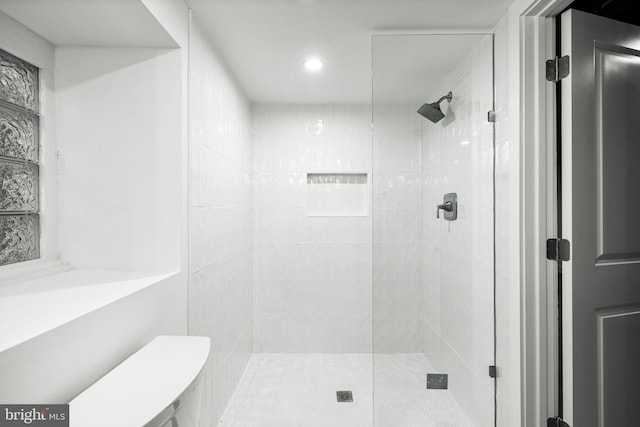 bathroom with a shower with door