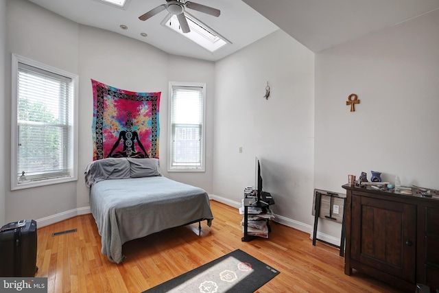 bedroom featuring multiple windows, ceiling fan, and light wood-type flooring