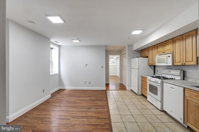 kitchen with light hardwood / wood-style flooring and white appliances