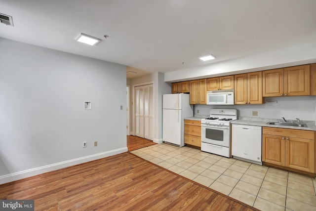 kitchen featuring white appliances, sink, and light tile patterned floors