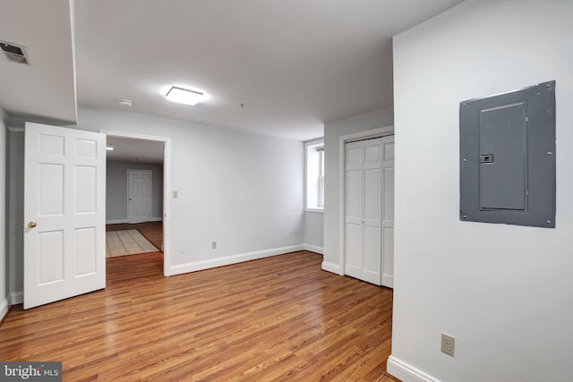 unfurnished room with light hardwood / wood-style floors and electric panel