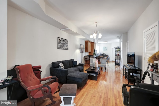 living room with light hardwood / wood-style flooring and a chandelier