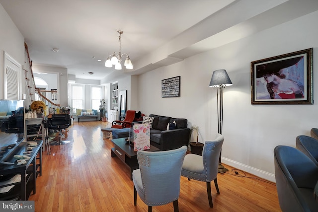 living room with an inviting chandelier and light hardwood / wood-style flooring