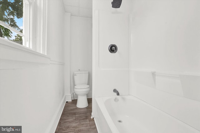 bathroom featuring bathtub / shower combination and toilet