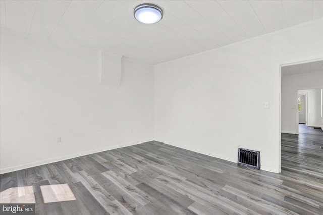 unfurnished room featuring wood-type flooring and ornamental molding