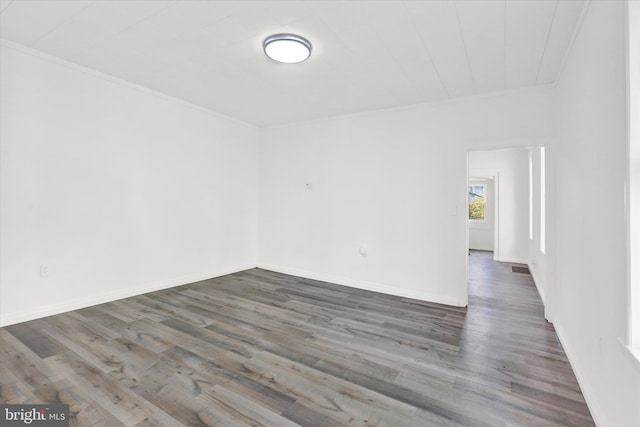 unfurnished room with dark hardwood / wood-style flooring and ornamental molding