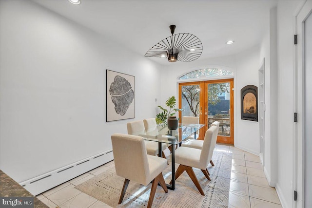 dining area with light tile patterned floors, a baseboard radiator, and french doors