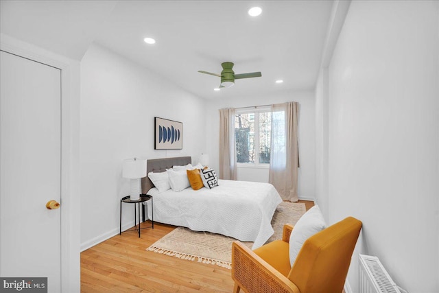 bedroom with radiator, ceiling fan, and hardwood / wood-style floors