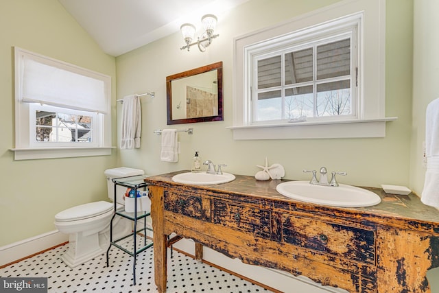 bathroom with vanity, vaulted ceiling, and toilet