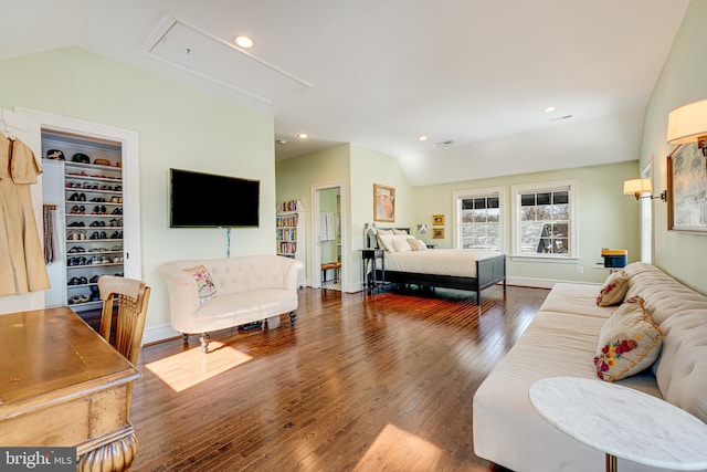 bedroom with dark wood-type flooring, a walk in closet, and lofted ceiling