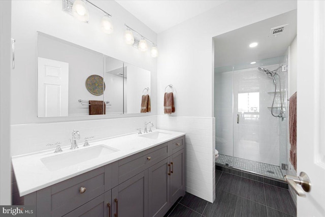 bathroom with vanity, tile patterned flooring, toilet, walk in shower, and tile walls