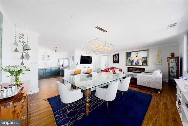 dining area with a chandelier, dark hardwood / wood-style floors, and ornamental molding