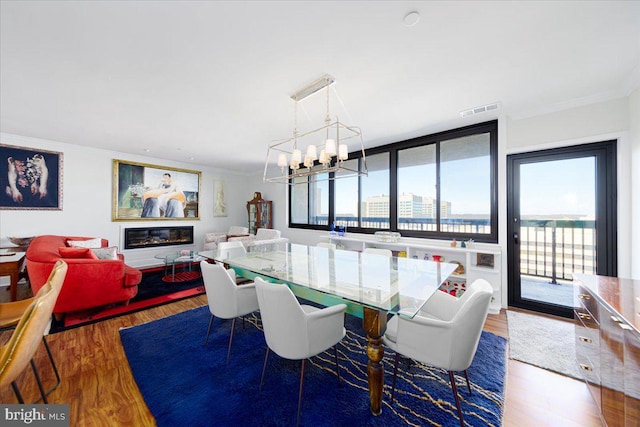 dining room with a wall of windows, ornamental molding, dark hardwood / wood-style floors, and a notable chandelier