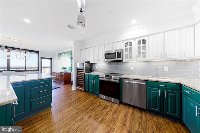 kitchen featuring decorative backsplash, appliances with stainless steel finishes, sink, hardwood / wood-style floors, and white cabinetry