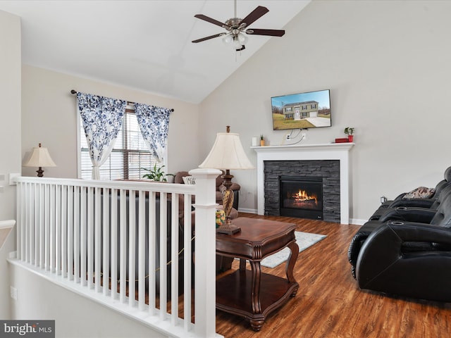 living room with ceiling fan, wood-type flooring, a fireplace, and vaulted ceiling