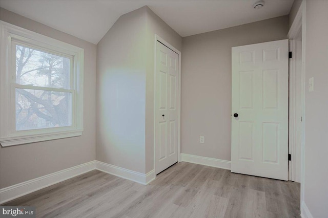 unfurnished bedroom with light hardwood / wood-style flooring and a closet