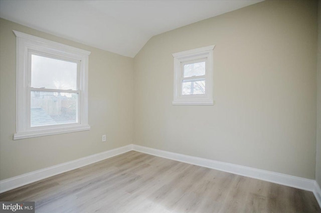 additional living space featuring light hardwood / wood-style floors and vaulted ceiling