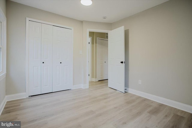 unfurnished bedroom featuring light hardwood / wood-style floors and a closet