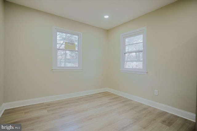 empty room featuring plenty of natural light and light hardwood / wood-style floors