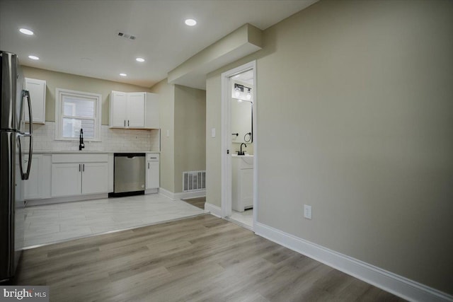 kitchen featuring white cabinets, stainless steel appliances, light hardwood / wood-style floors, and sink