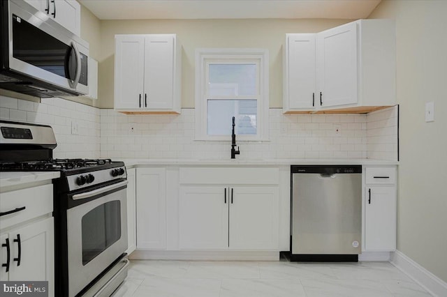 kitchen featuring tasteful backsplash, sink, white cabinets, and stainless steel appliances