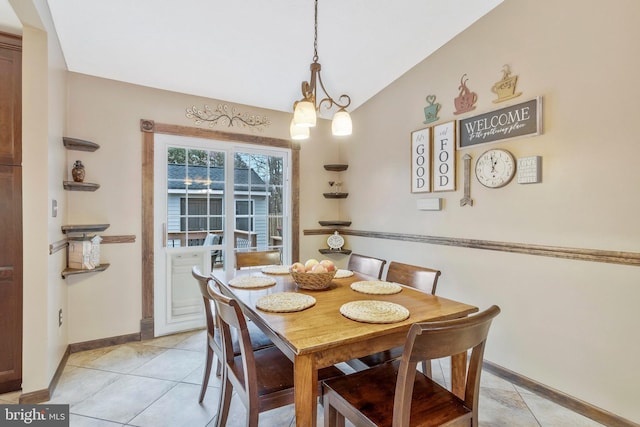 dining room featuring an inviting chandelier, lofted ceiling, and light tile patterned flooring