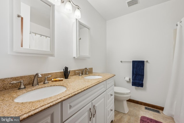 bathroom featuring tile patterned floors, vanity, and toilet