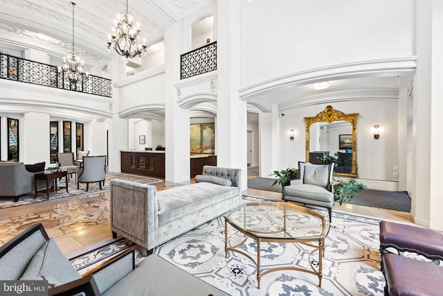 living room with crown molding, a towering ceiling, and a chandelier