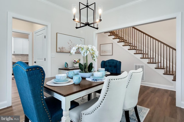 dining area featuring crown molding, dark wood-type flooring, and an inviting chandelier