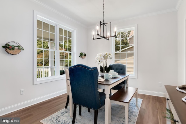 dining room featuring hardwood / wood-style flooring, crown molding, and a chandelier