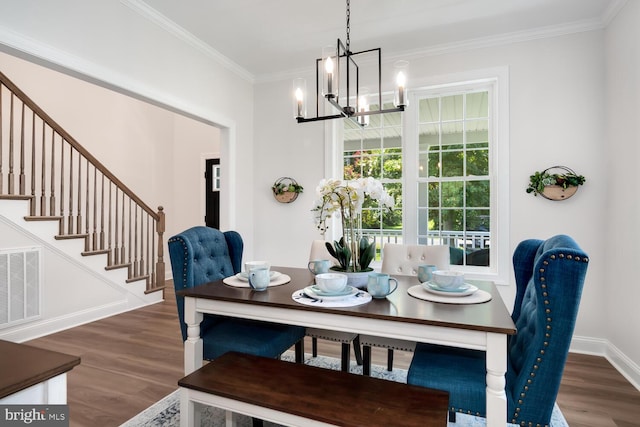 dining area featuring dark hardwood / wood-style flooring, crown molding, and an inviting chandelier